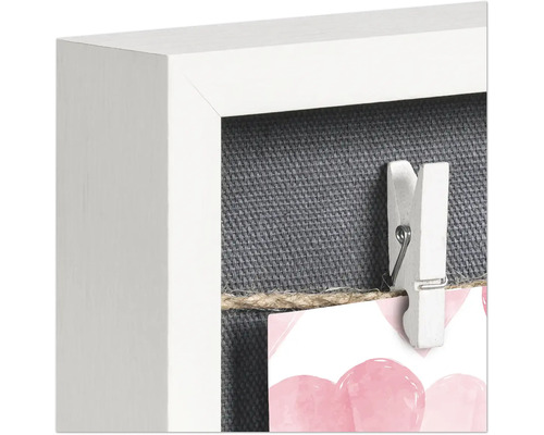 Detailansicht eines Bilderrahmens mit einer Wäscheklammer an einer Schnur