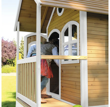 Kind betritt ein Holzspielhaus mit Fenstern und Veranda