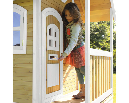 Mädchen steckt Brief in Briefkasten eines Spielhauses aus Holz