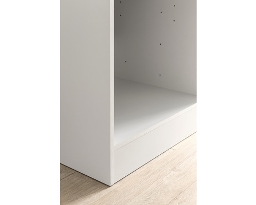 Detailansicht eines weißen Küchenschranks auf einem Holzboden.