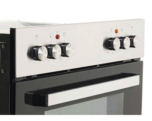 Gros plan d''une cuisinière argentée avec des boutons de commande et une poignée sur la porte du four