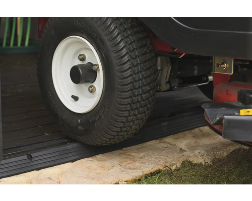 Detailansicht eines Rasentraktorreifens auf einer schwarzen Türrampe