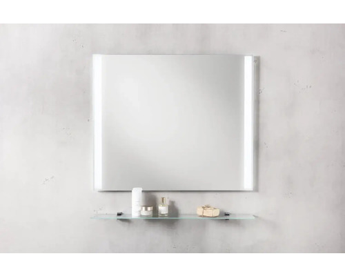 Miroir rectangulaire avec éclairage et étagère en verre dans la salle de bains.