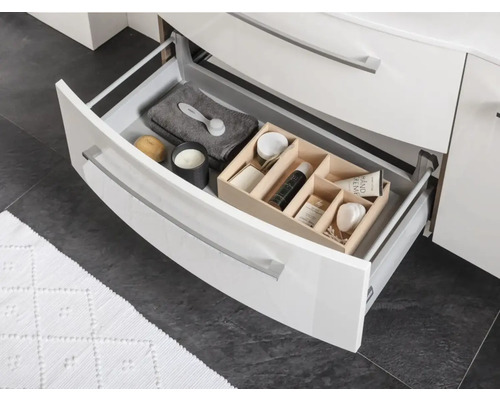 Geöffnete Schublade eines Badezimmerschranks mit verschiedenen Badutensilien zur Aufbewahrung