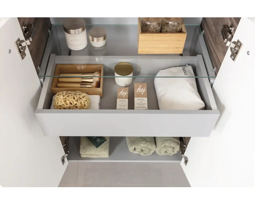 Badezimmerschrank mit offenem Schubfach und diversen Badutensilien