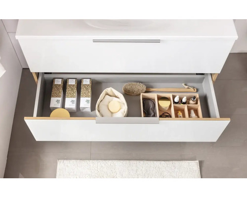 Offene Schublade eines Badezimmerschranks mit Kosmetikprodukten und Accessoires