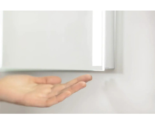 Vue détaillée d''une armoire de toilette avec une main au premier plan