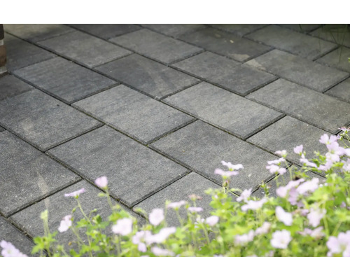 Verlegte Pflastersteine im Aussenbereich mit Blumenbeet