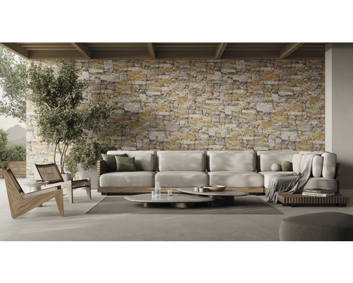 Salon avec canapé d''angle, tables basses et mur en pierre