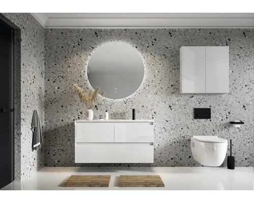 Salle de bain moderne avec meuble-lavabo, miroir, armoire suspendue et toilettes devant un mur à motifs.