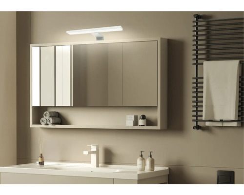 Salle de bain moderne avec armoire de toilette, lavabo, sèche-serviettes et design minimaliste