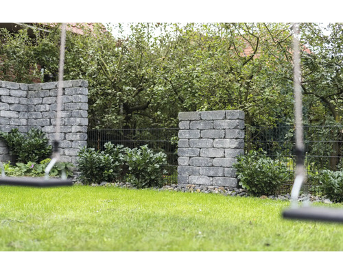 Jardin avec pelouse, murs de pierre plantés et balançoire