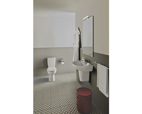 Badezimmer mit Toilette, Waschbecken, Spiegel, Bademantel und Hocker