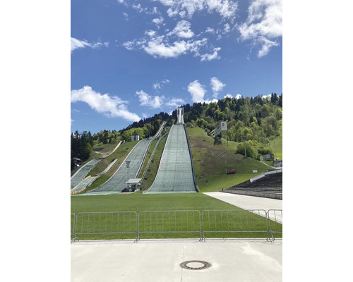 Skisprungschanze auf einem Hügel unter blauem Himmel