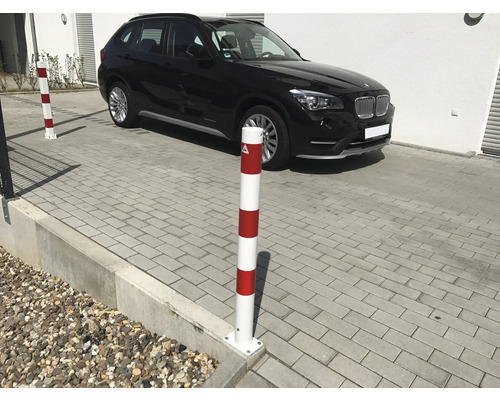 Poteau de barrage avec une voiture noire en arrière-plan