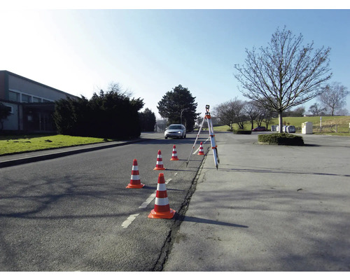 Szene mit Leitkegeln und einem Nivelliergerät auf einer Straße zur Verkehrsleitung.