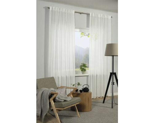 Salon avec rideaux blancs transparents devant une fenêtre, fauteuil, table d''appoint et lampadaire