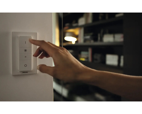 Une main actionne un interrupteur pour contrôler l''éclairage.