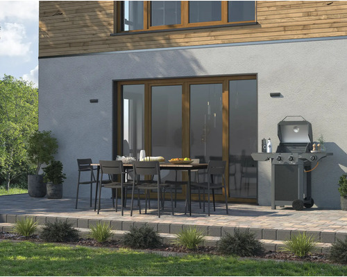 Terrasse mit Grill, Esstisch und Stühlen vor dem Haus