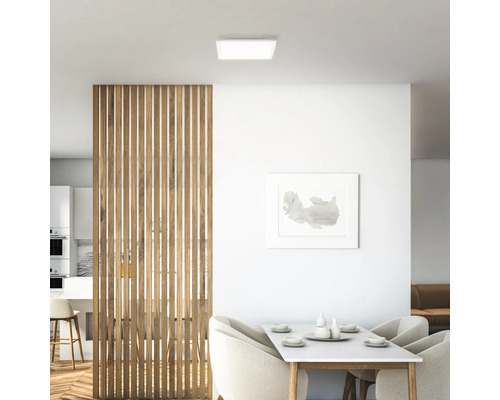 Intérieur lumineux avec plafonnier carré, cloison en bois et table à manger.