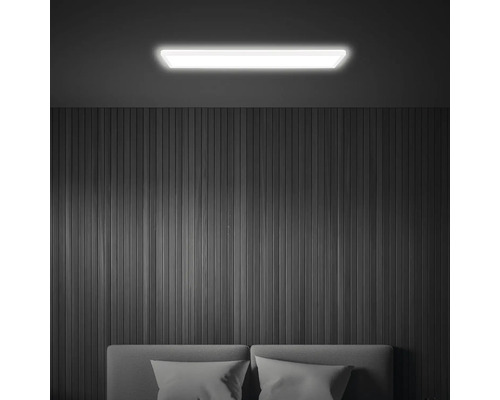 Plafond de pièce éclairé avec plafonnier LED au-dessus du lit