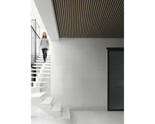 Heller Raum mit Holzdecke, Treppe und einer Person.