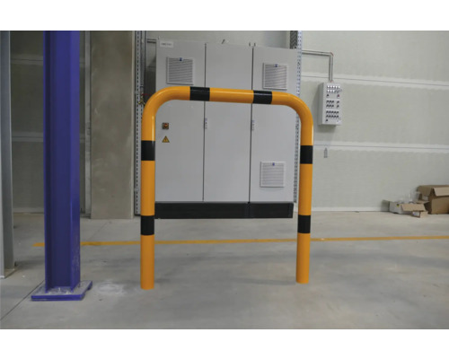 Arceau de protection jaune avec marquages noirs devant un boîtier de distribution.