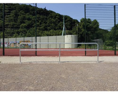 Photo extérieure d''un terrain de football avec un pare-ballons et une rambarde.