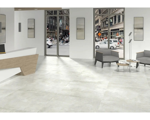 Pièce lumineuse avec carrelage au sol, réception et coin salon donnant sur la rue