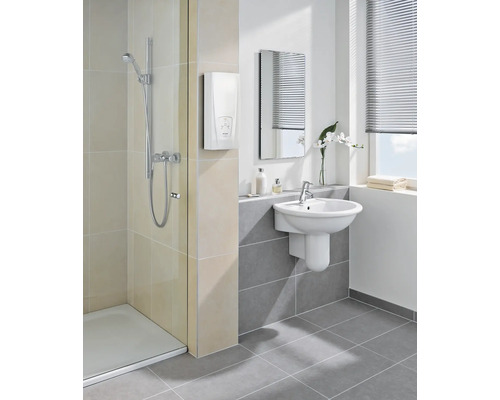 Helles Badezimmer mit Dusche, Waschbecken, Spiegel und elektronischem Durchlauferhitzer.