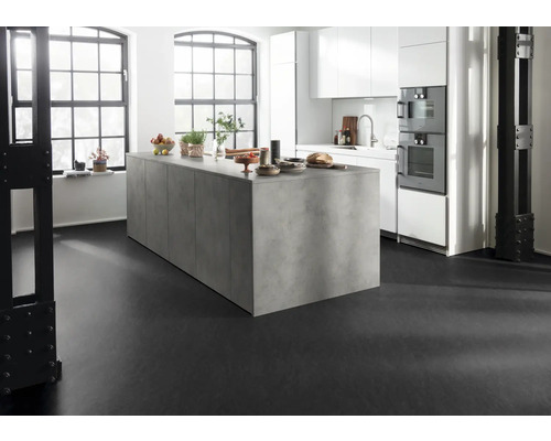 Cuisine lumineuse avec îlot de cuisine, armoires blanches et sol noir.