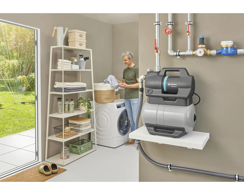 Buanderie avec machine à laver, étagère, surpresseur et personne