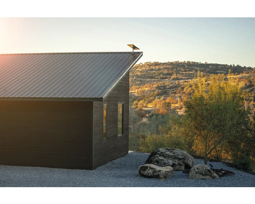 Maison moderne avec toit en métal dans un environnement rural.