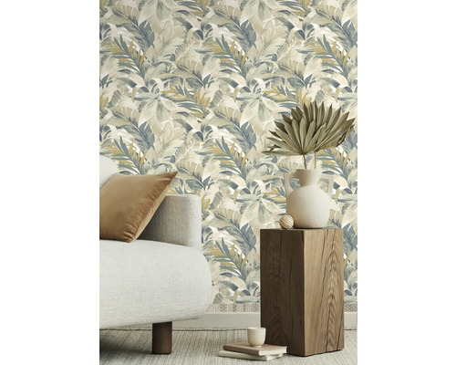 Dekoratives Zimmer mit Tapete mit Blattmuster, Sofa und Holzhocker