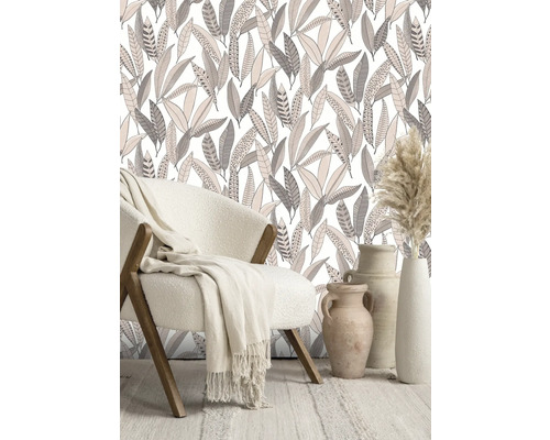 Pièce décorative avec fauteuil, couverture, papier peint à motif de feuilles et vases.