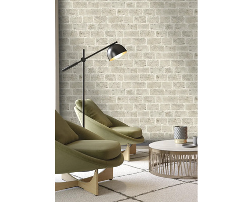 Salon avec papier peint à motifs de briques, fauteuils, lampadaire et table basse