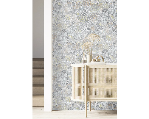 Einrichtungsbeispiel mit floral gemusterter Tapete und einem hellen Holzschrank