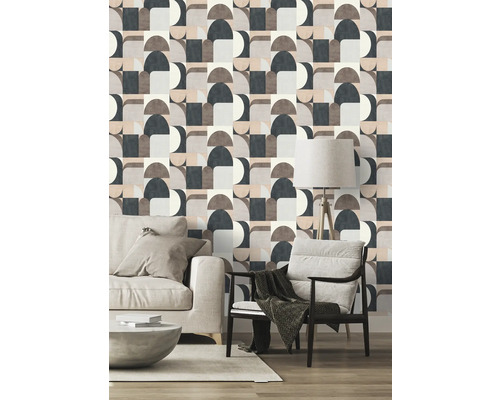 Salon avec papier peint géométrique, canapé et fauteuil pour un design intérieur moderne.