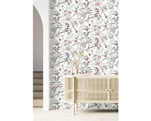 Raum mit floral gemusterter Tapete und hellem Holzschrank