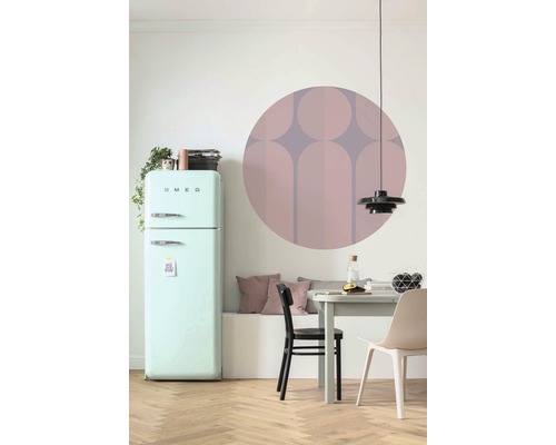 Salle à manger avec réfrigérateur, table, chaises et décoration murale.