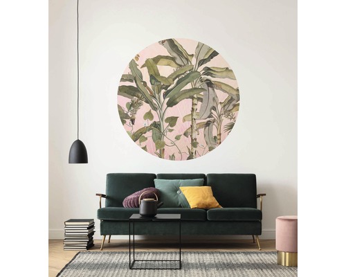 Wohnzimmer mit grüner Couch, Teppich und Wanddekor mit Pflanzenmuster