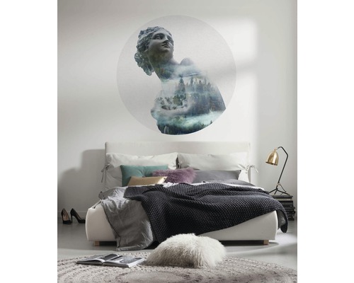 Schlafzimmer mit Bett, Lampe, Teppich und Wanddekoration mit antiker Statue und Waldmotiv