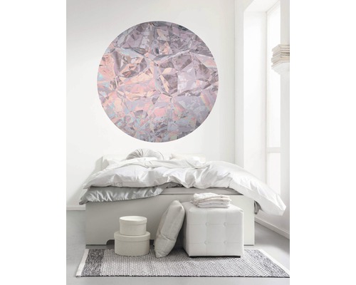 Chambre avec lit, tabouret, tapis et décoration murale ronde en forme de cristal pour une ambiance lumineuse.