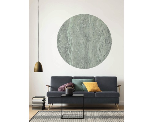 Wohnzimmer mit Sofa, Couchtisch, Teekanne, Kissen, Lampe, Bücherstapel, Teppich und Wandbild