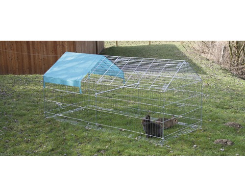 Enclos pour petits animaux avec couverture et lapins dans le jardin