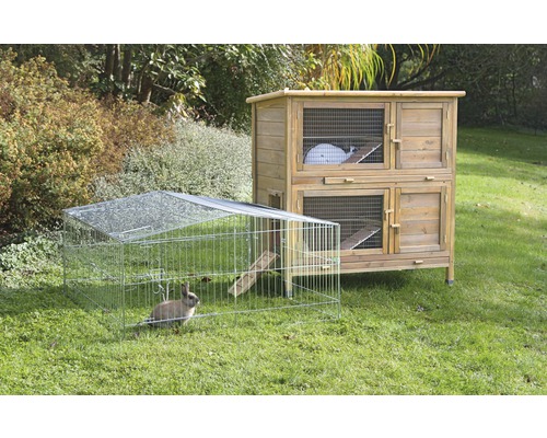Doppelstöckiger Hasenstall aus Holz und Freilaufgehege mit Kaninchen im Garten.