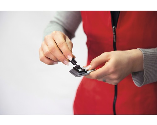 Une femme assemble une tondeuse à cheveux