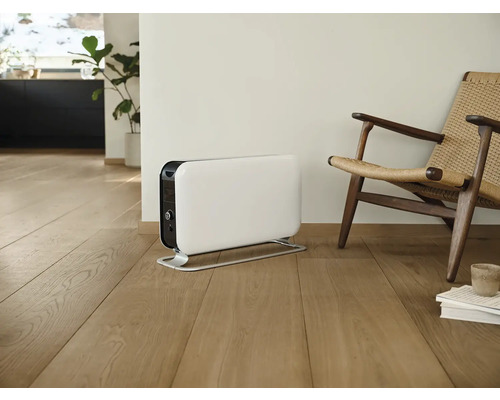 Radiateur blanc à côté d''une chaise dans une pièce lumineuse.