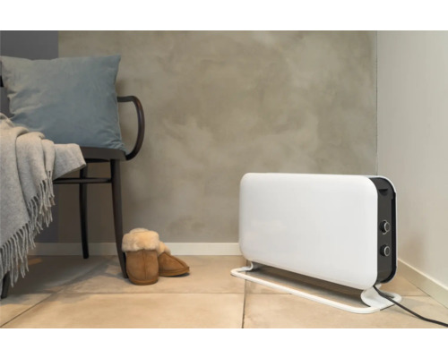 Scène avec un radiateur, une chaise avec un coussin et une couverture, et des chaussons