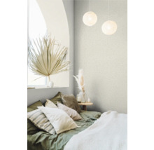 Schlafzimmer mit Bett, Kissen, Beistelltisch und Dekorationsartikeln